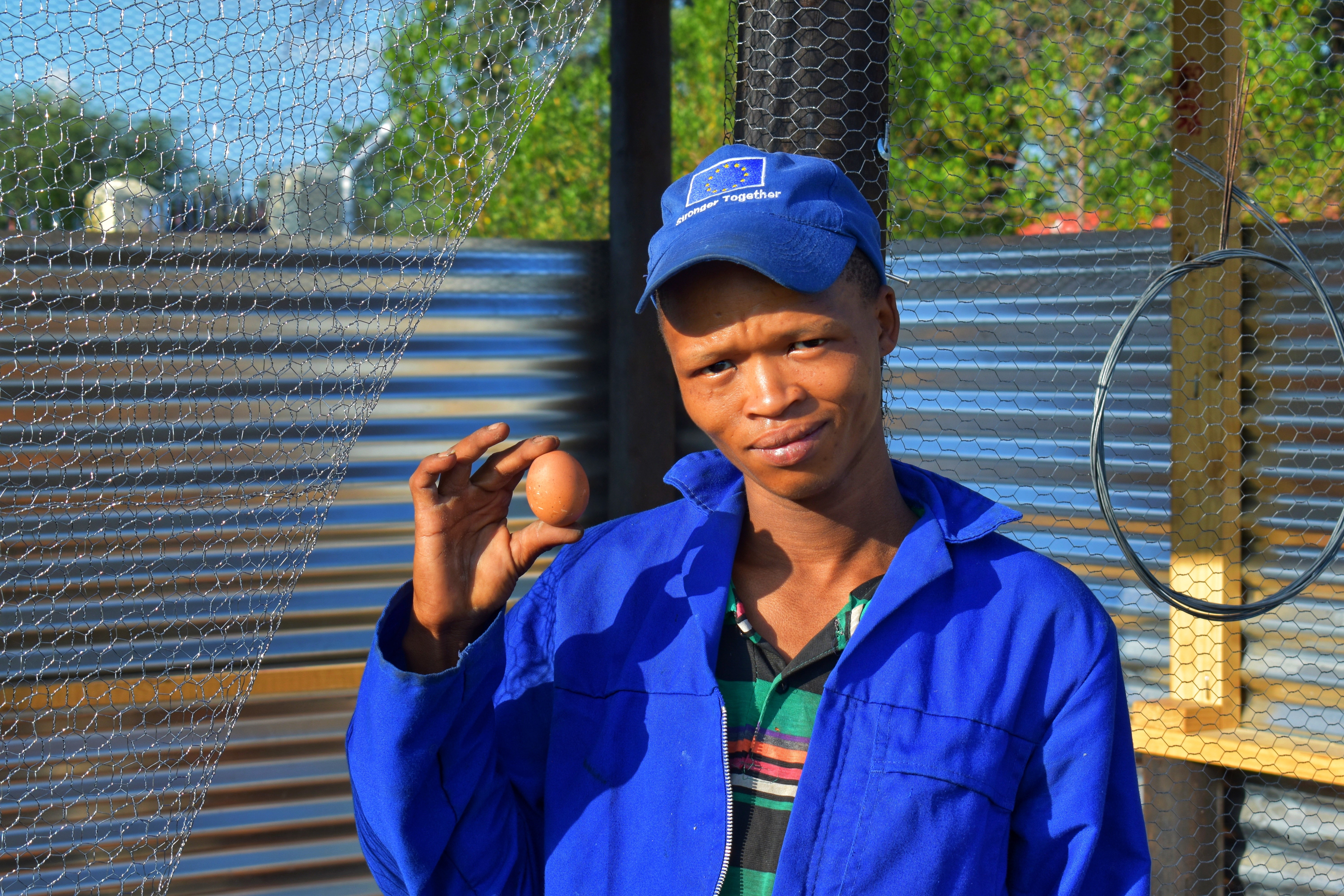 G!ao _Kunta, one of the youth trainees from Tsumkwe, holds an egg he found in the poultry structure