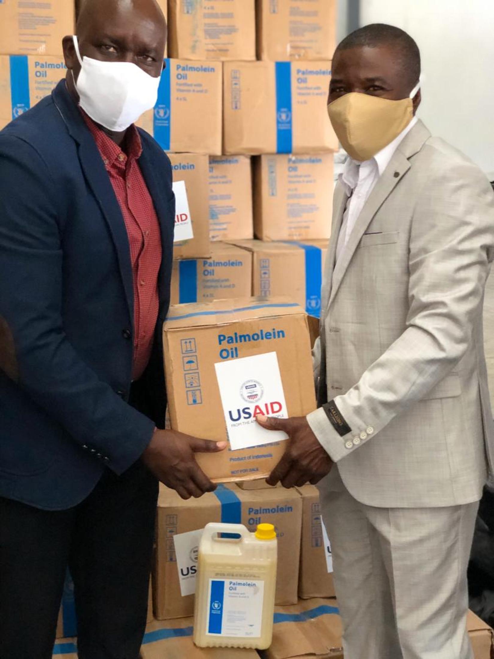(From LtoR) Mr. Elvis Odeke (WFP) poses for a photo with Hon. Bonifatius Wakudumo (Governor of Kavango East) during inspection of the vegetable oil at warehouse