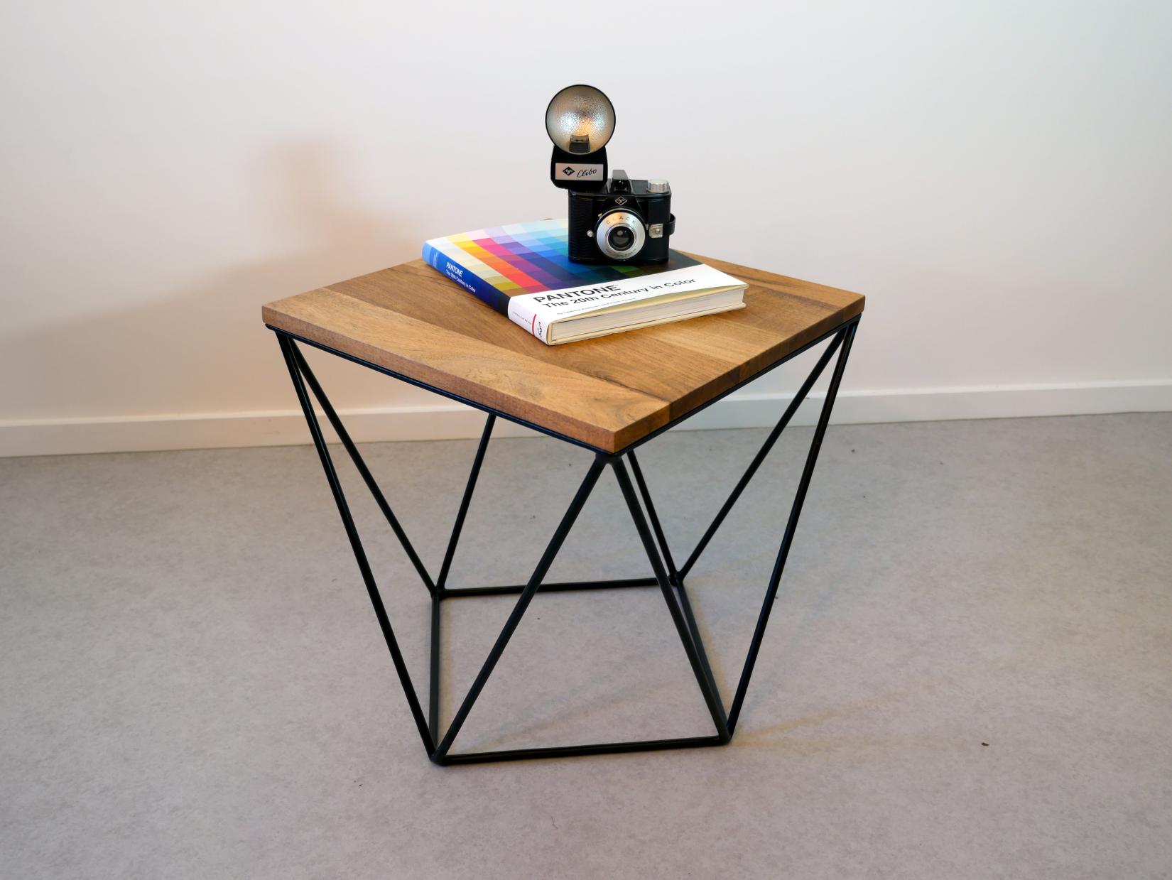 A book and camera on top of a contemporary-styled side table designed by Tabled Namibia