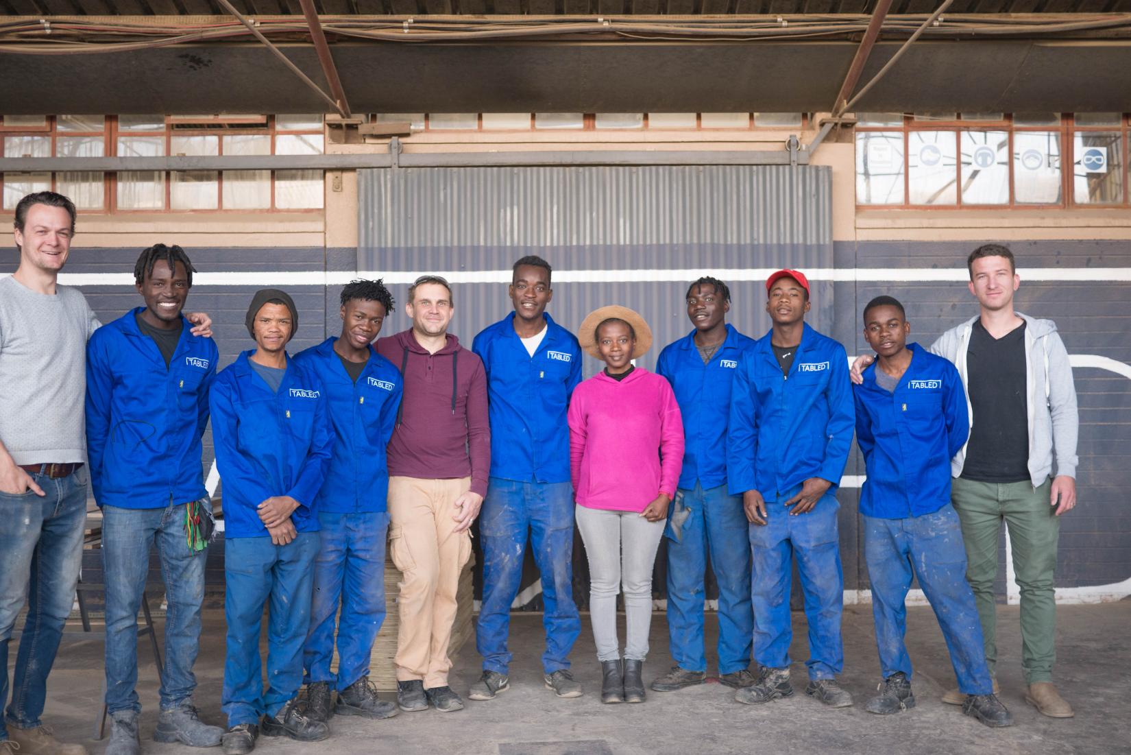 Eleven members of the Tabled Namibia team stand while posing for a picture.