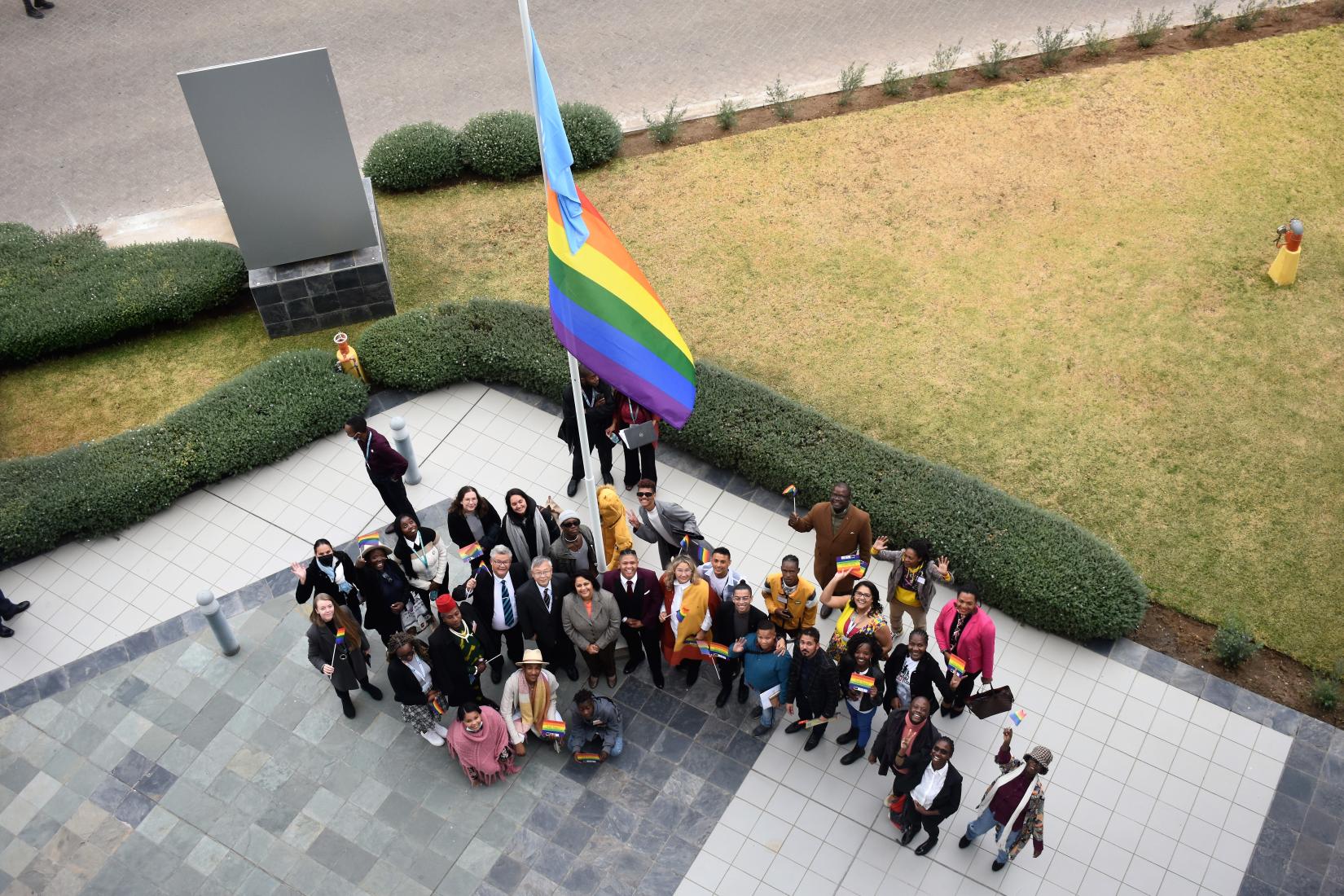 Participants proudly watch as the LGBTQ+ and UN flag is raised