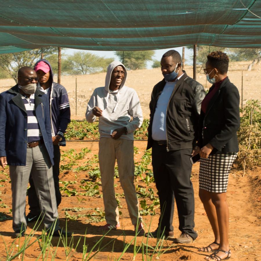 Youth gardening project beneficiary Kornelius Shoombe (middle, grey hoodie) sharing a light hearted moment with FAO and MSYNS officials.