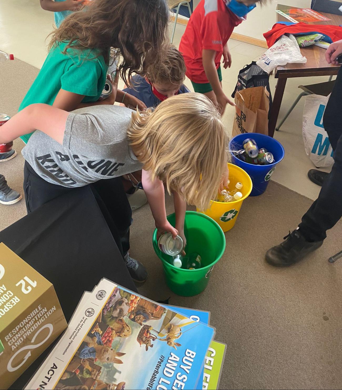 Children sort materials in recycling bins