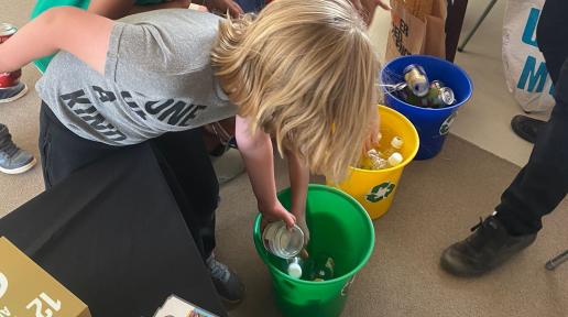 Children sort materials in recycling bins